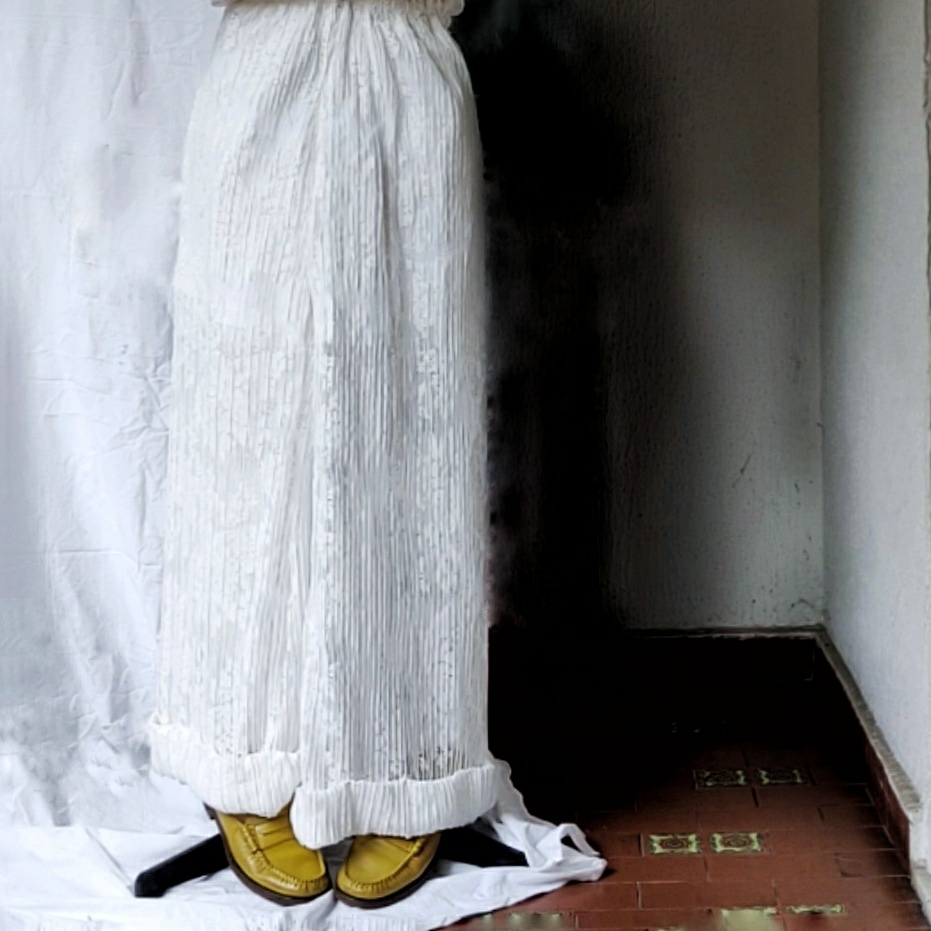 Elegant lady wide trousers in fine white floral macramé that reveals the legs in a semi-sheer effect. Lined interior, cuffed hem, and elastic waistband.